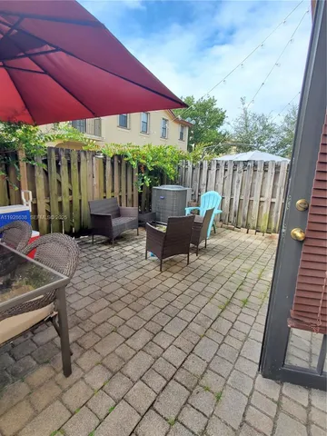 a view of a patio with table and chairs under an umbrella