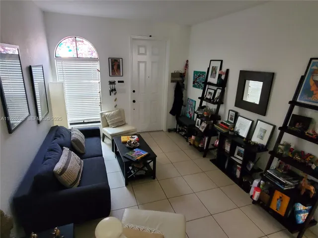 a living room with furniture a window and a flat screen tv