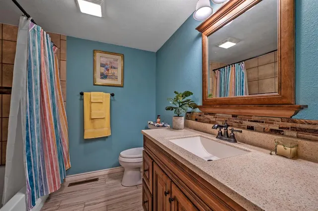 a bathroom with a sink a toilet and mirror