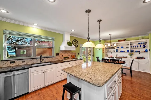 a kitchen with kitchen island granite countertop wooden cabinets a stove and a center island