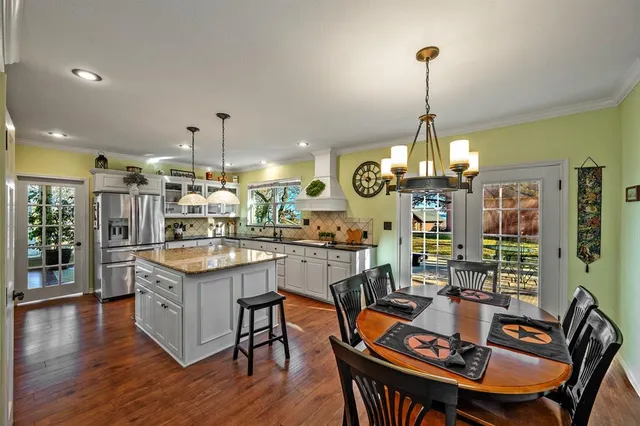a view of a dining room and livingroom with furniture wooden floor a chandelier