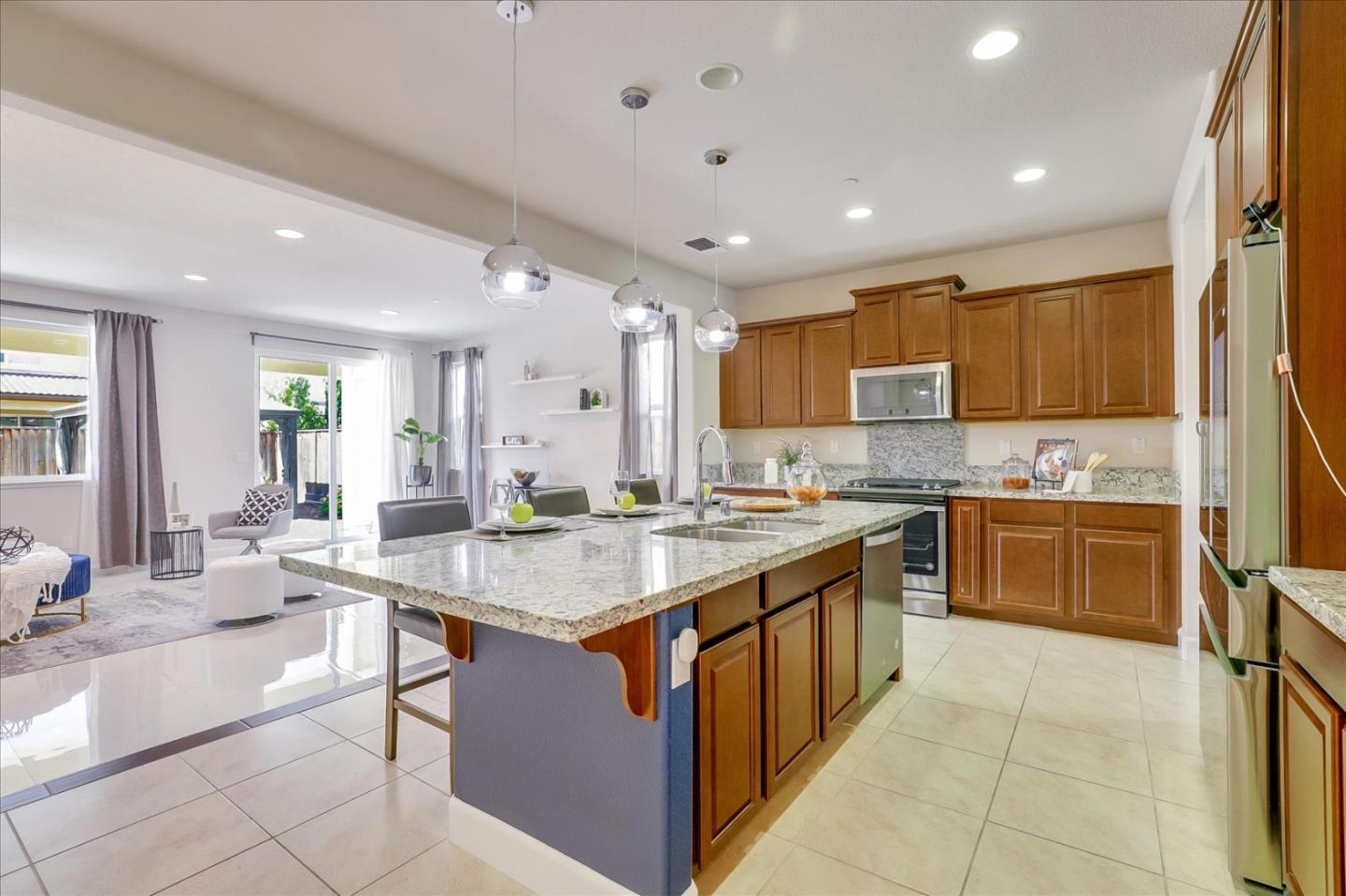 1081 Cabrillo Drive Hollister, CA 95023 - Photo 12 of 60 a kitchen with stainless steel appliances granite countertop a stove top oven a sink a counter top space and cabinets