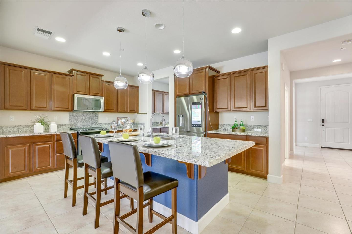 1081 Cabrillo Drive Hollister, CA 95023 - Photo 10 of 60 a kitchen with stainless steel appliances granite countertop table chairs sink and cabinets
