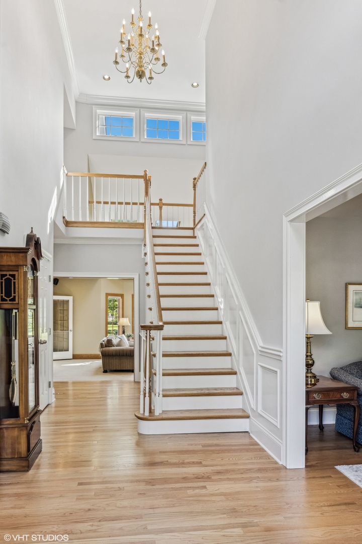 437 Stagecoach Run Glen Ellyn, IL 60137 - Photo 3 of 45 a view of a hallway with wooden floor and a chandelier
