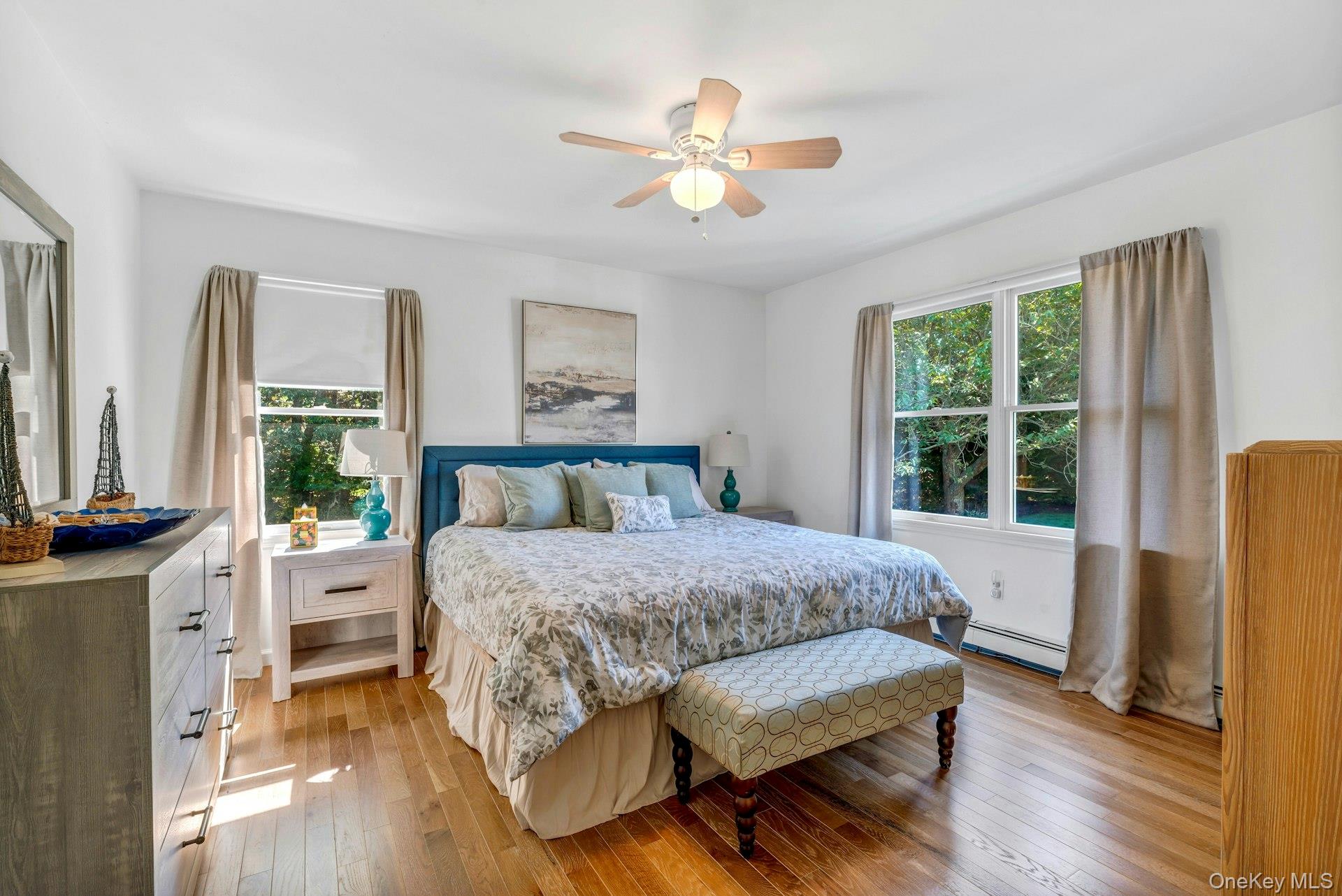3045 Rocky Point Road East Marion, NY 11939 - Photo 10 of 22 a bedroom with a bed and a large window with wooden floor