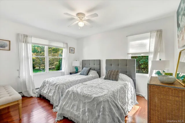 a bedroom with a bed and a large window with wooden floor