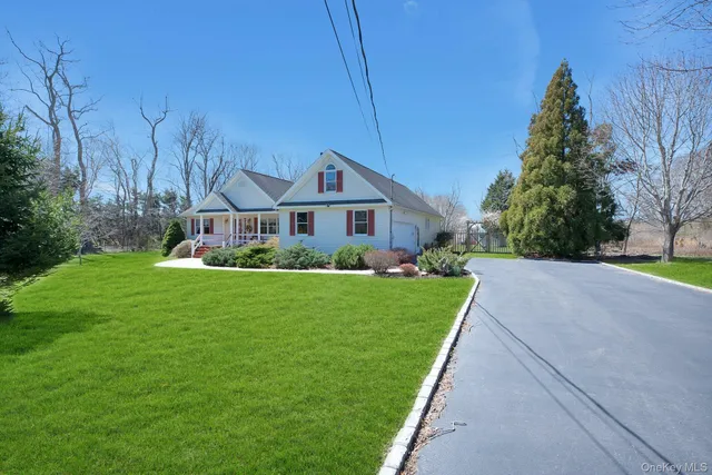 a front view of a house with a yard and potted plants