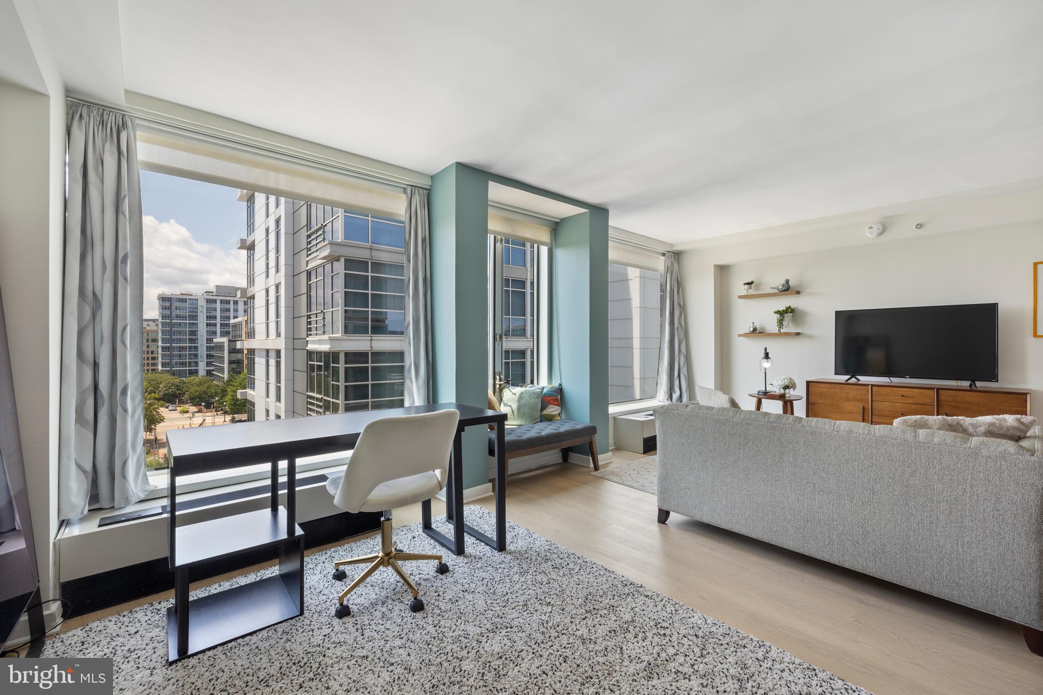 1101 3rd Street Southwest, Unit 705 Washington, DC 20024 - Photo 1 of 38 a living room with furniture and a flat screen tv