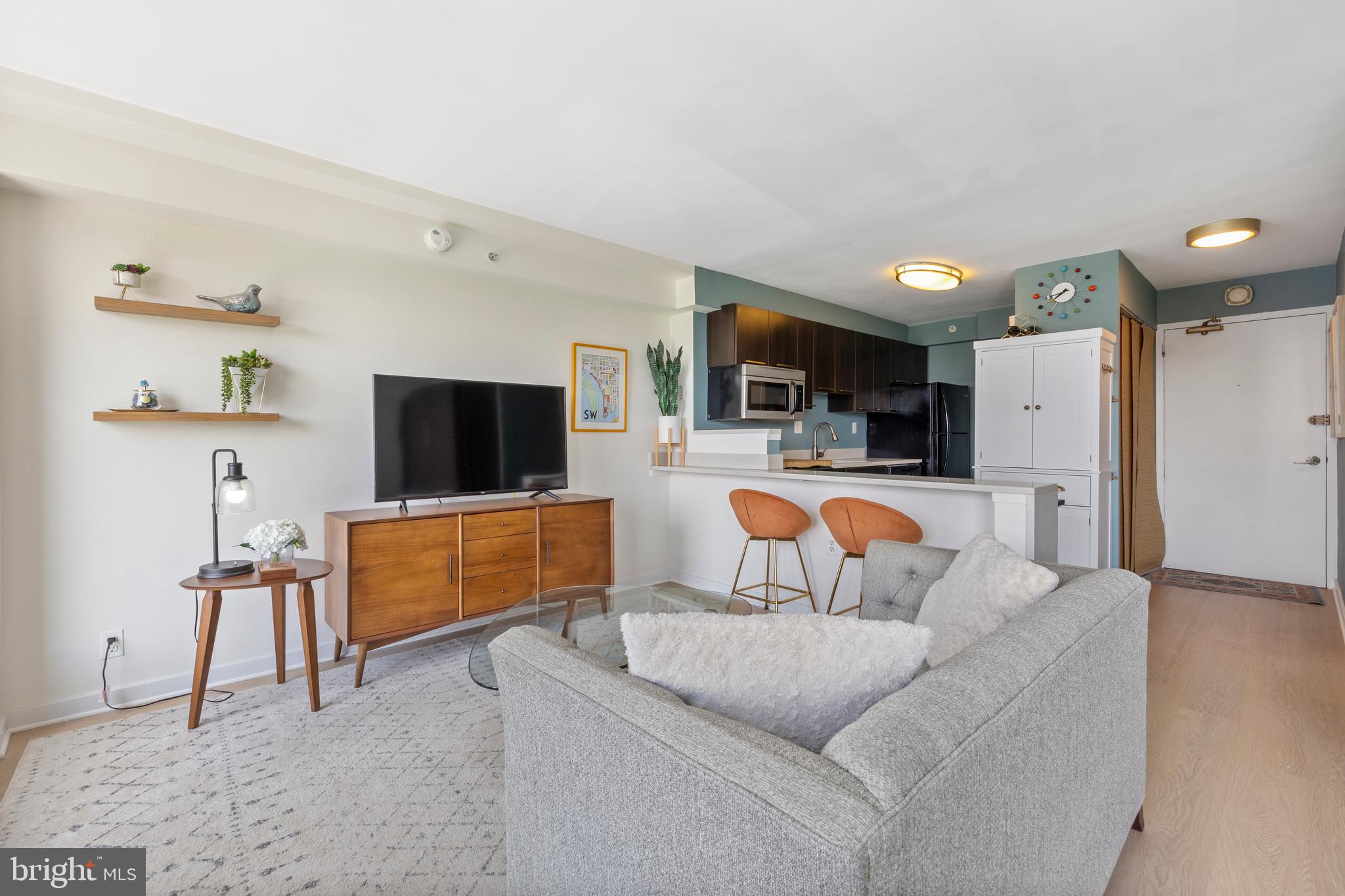 1101 3rd Street Southwest, Unit 705 Washington, DC 20024 - Photo 13 of 38 a living room with furniture and a flat screen tv