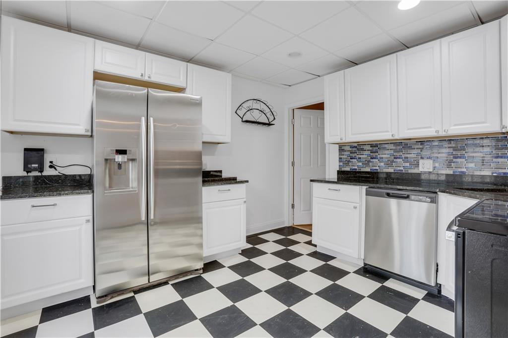 803 Rocky Ridge Court Canton, GA 30114 - Photo 62 of 74 a kitchen with a refrigerator a sink and white cabinets