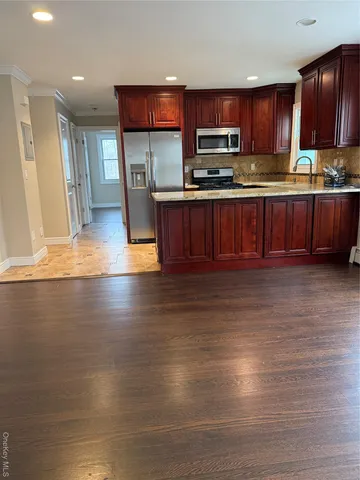 a kitchen with stainless steel appliances wooden cabinets a stove top oven a sink and dishwasher