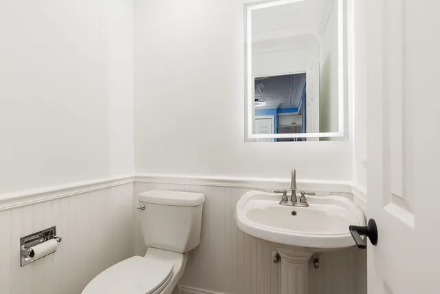 a bathroom with a sink mirror and toilet