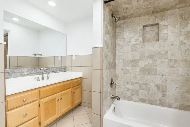 a bathroom with a sink double vanity mirror and a bathtub