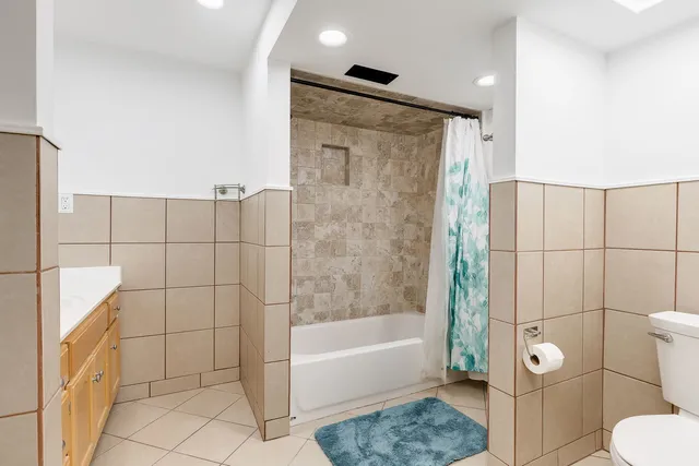 a bathroom with a granite countertop bathtub shower and toilet