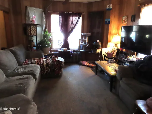 a room with a table chairs and a kitchen view