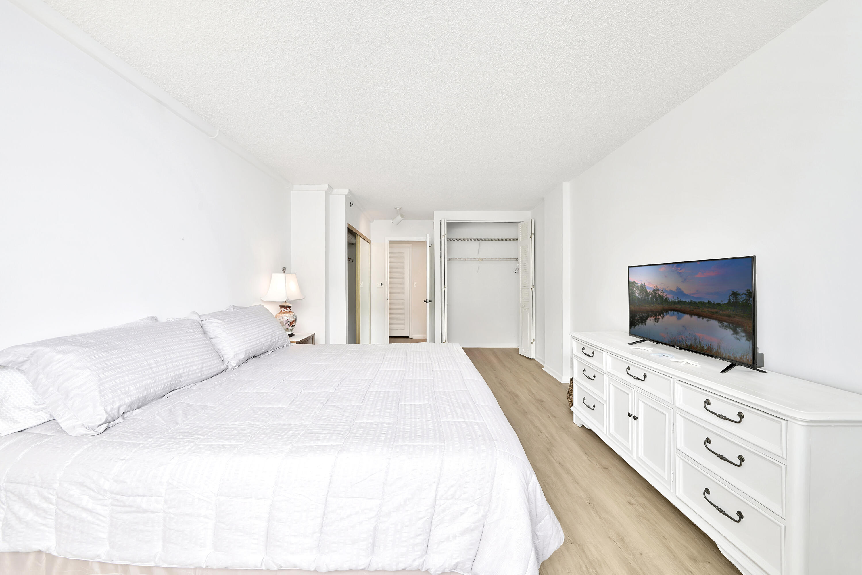 3215 South Ocean Boulevard, Unit 707 Highland Beach, FL 33487 - Photo 13 of 37 a bedroom with a flat screen tv on the dresser and a flat screen tv