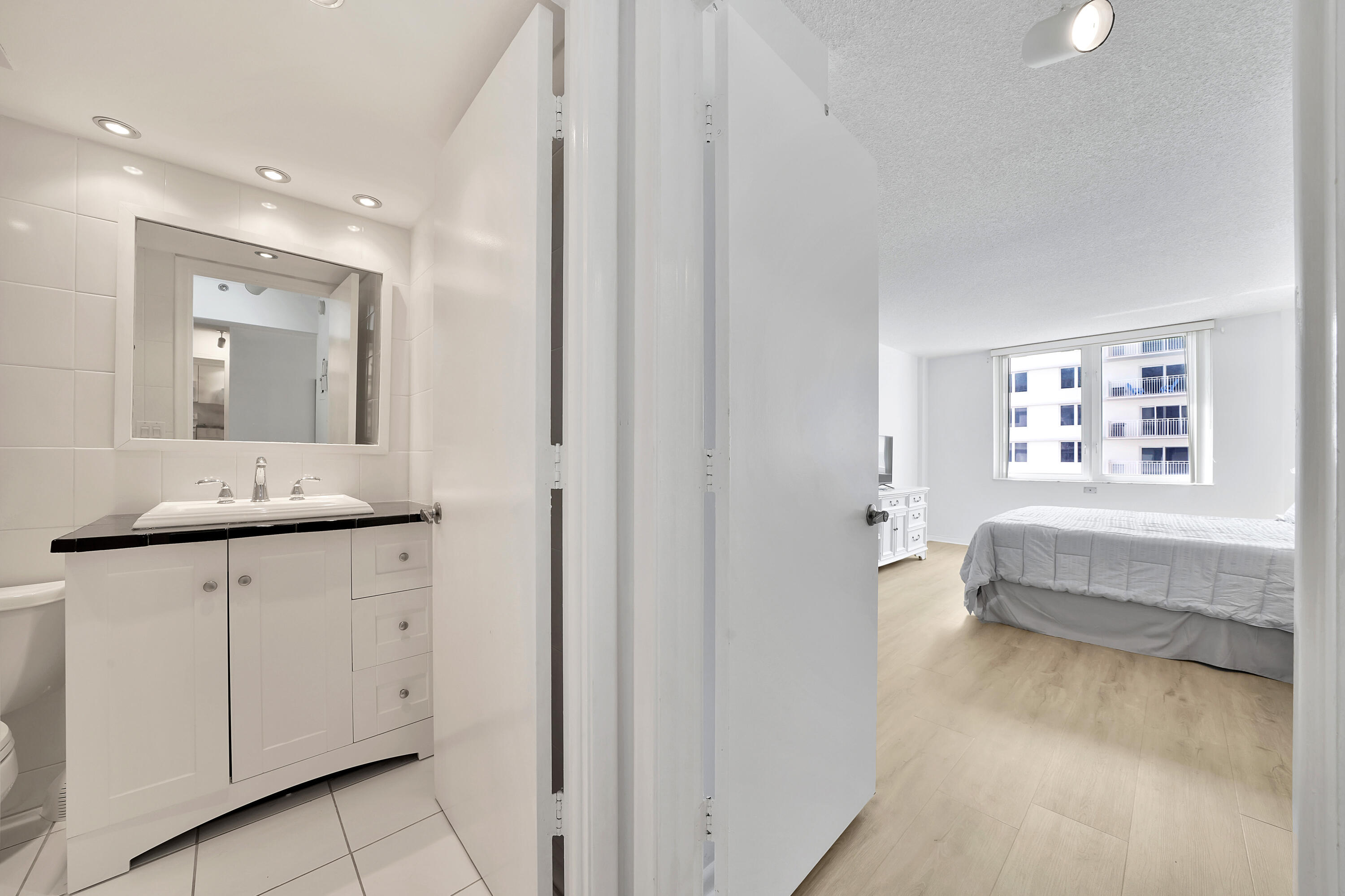 3215 South Ocean Boulevard, Unit 707 Highland Beach, FL 33487 - Photo 15 of 37 a en suite bathroom with a granite countertop sink and a mirror