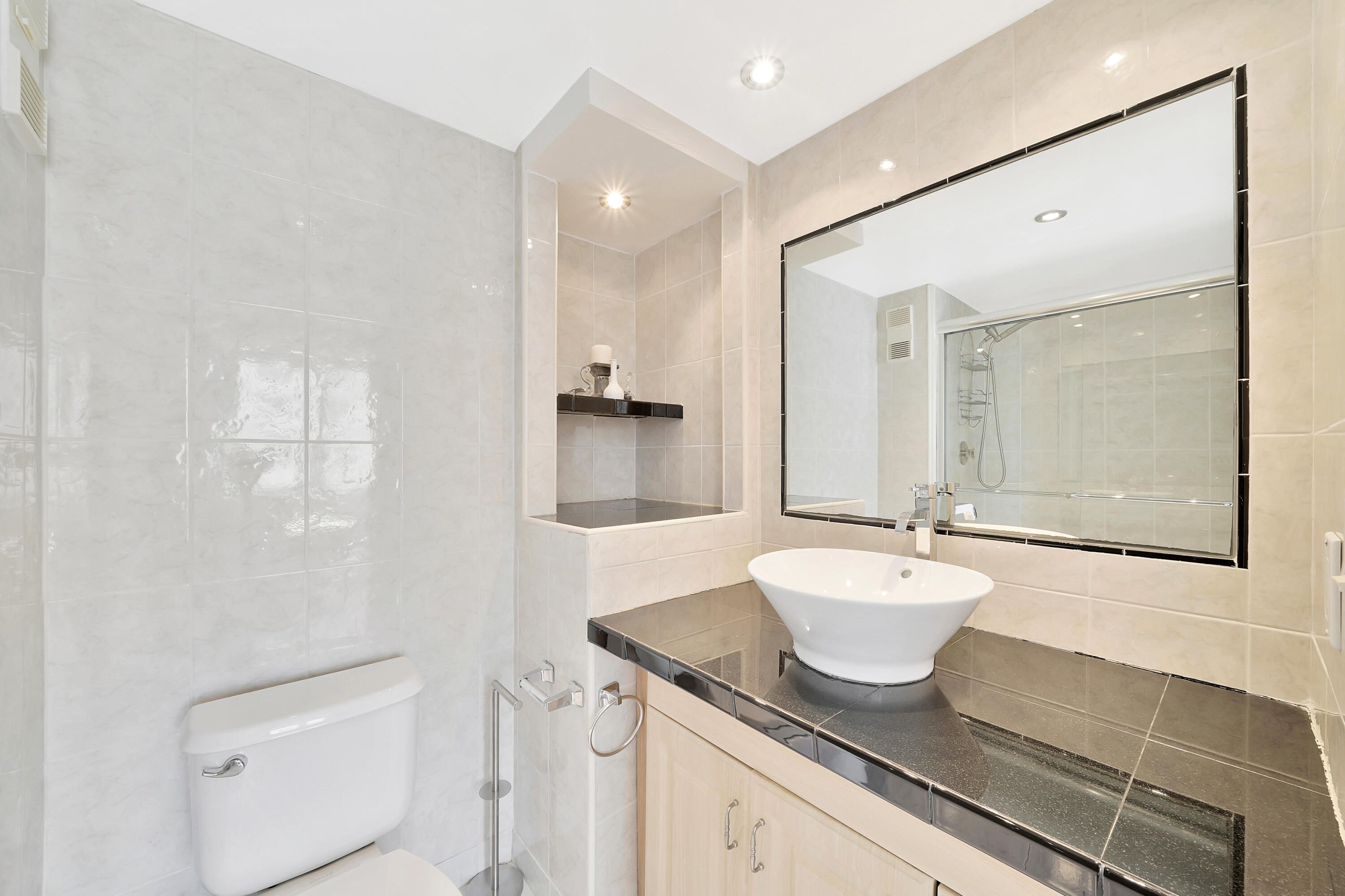 3215 South Ocean Boulevard, Unit 707 Highland Beach, FL 33487 - Photo 21 of 37 a bathroom with a granite countertop sink a toilet and a mirror