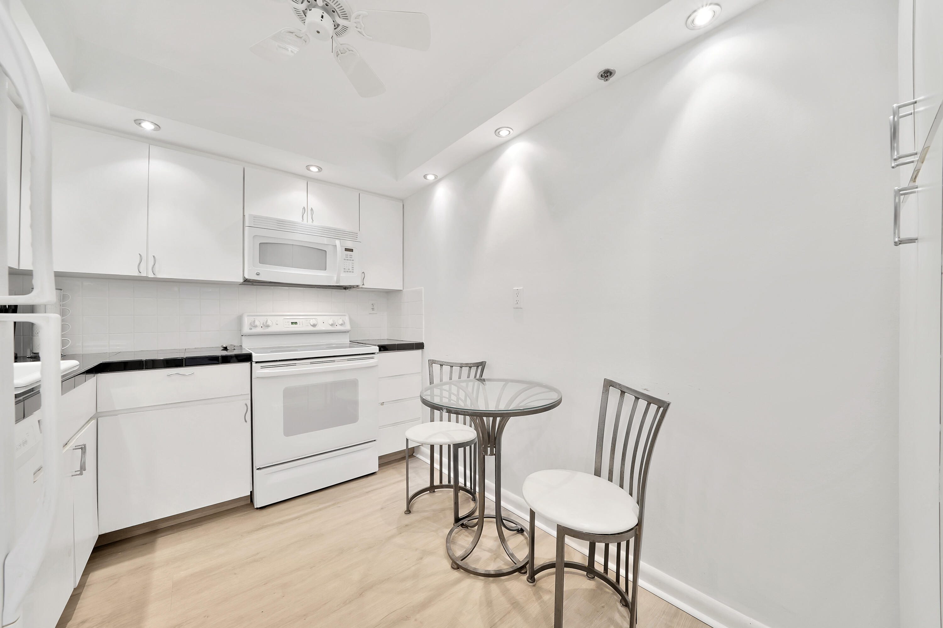 3215 South Ocean Boulevard, Unit 707 Highland Beach, FL 33487 - Photo 10 of 37 a kitchen with cabinets and chairs