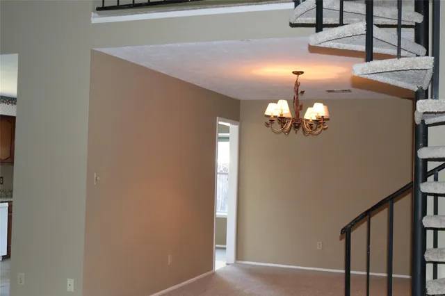 a view of a chandelier fan and entryway
