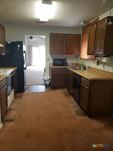 a large kitchen with granite countertop a sink and cabinets