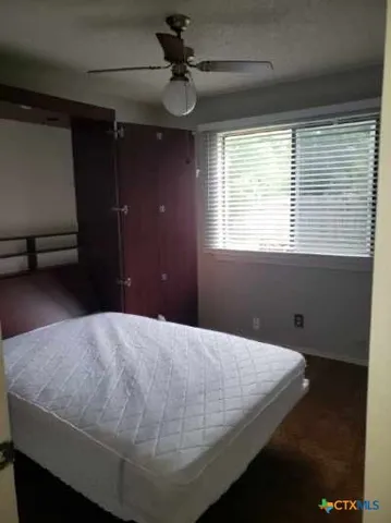 a bed sitting in a bedroom next to a window