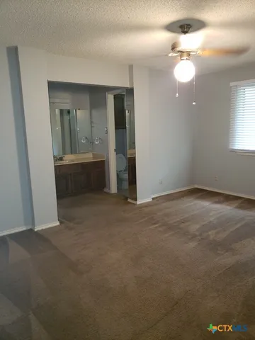 an empty room with fan and entrance