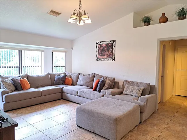 a open kitchen with stainless steel appliances granite countertop a refrigerator a stove top oven a dining table and chairs with wooden floor