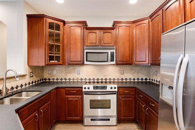 a kitchen with stainless steel appliances granite countertop a sink stove and refrigerator