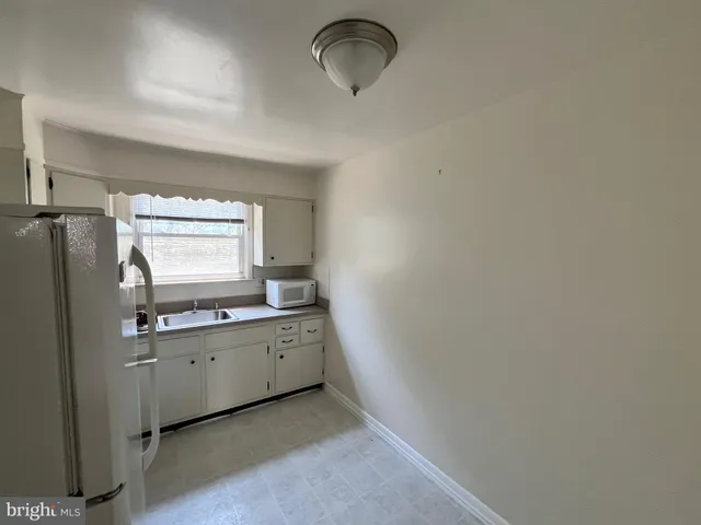 a kitchen with white cabinets and white appliances