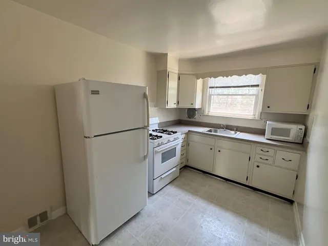 a kitchen with cabinets appliances a sink and a window