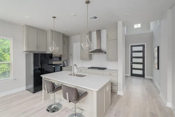 a kitchen with stainless steel appliances kitchen island granite countertop a sink refrigerator and cabinets