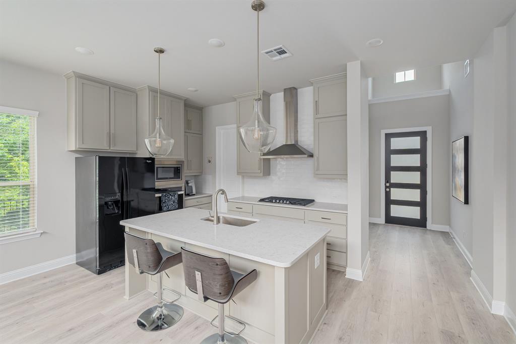 1412 Bear Path Way Gunter, TX 75058 - Photo 4 of 37 a kitchen with stainless steel appliances kitchen island granite countertop a sink refrigerator and cabinets