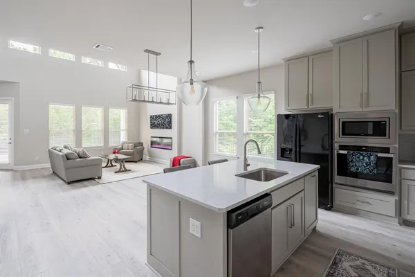 a kitchen with sink refrigerator and couch