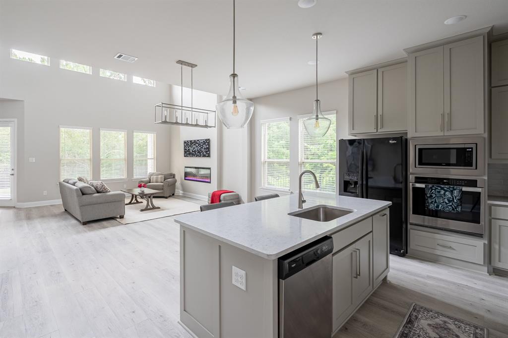 1412 Bear Path Way Gunter, TX 75058 - Photo 6 of 37 a kitchen with sink refrigerator and couch