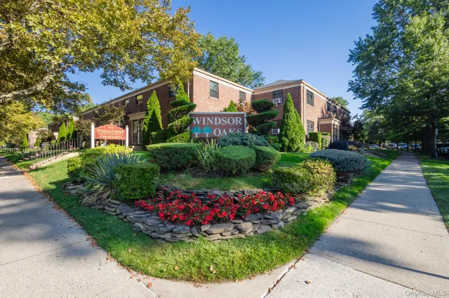 a front view of a house with a yard and potted plants