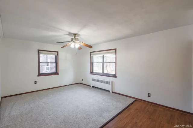 an empty room with a window and a ceiling fan
