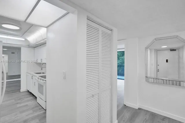 a view of a kitchen with white cabinets and wooden floor