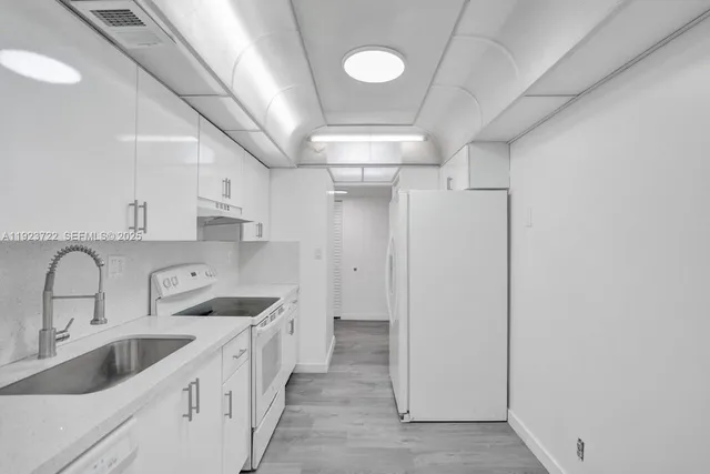 a kitchen with stainless steel appliances a sink and cabinets
