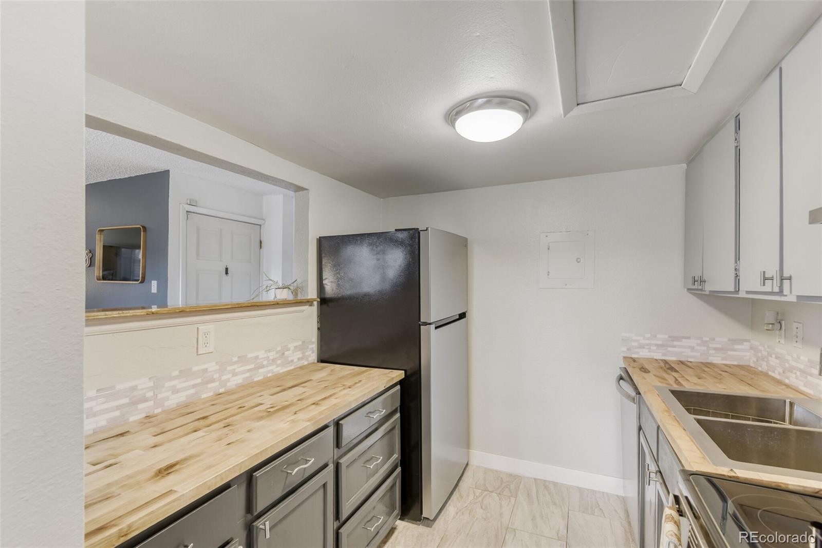 3428 South Locust Street, Unit B Denver, CO 80222 - Photo 4 of 9 a kitchen with a stove and a refrigerator