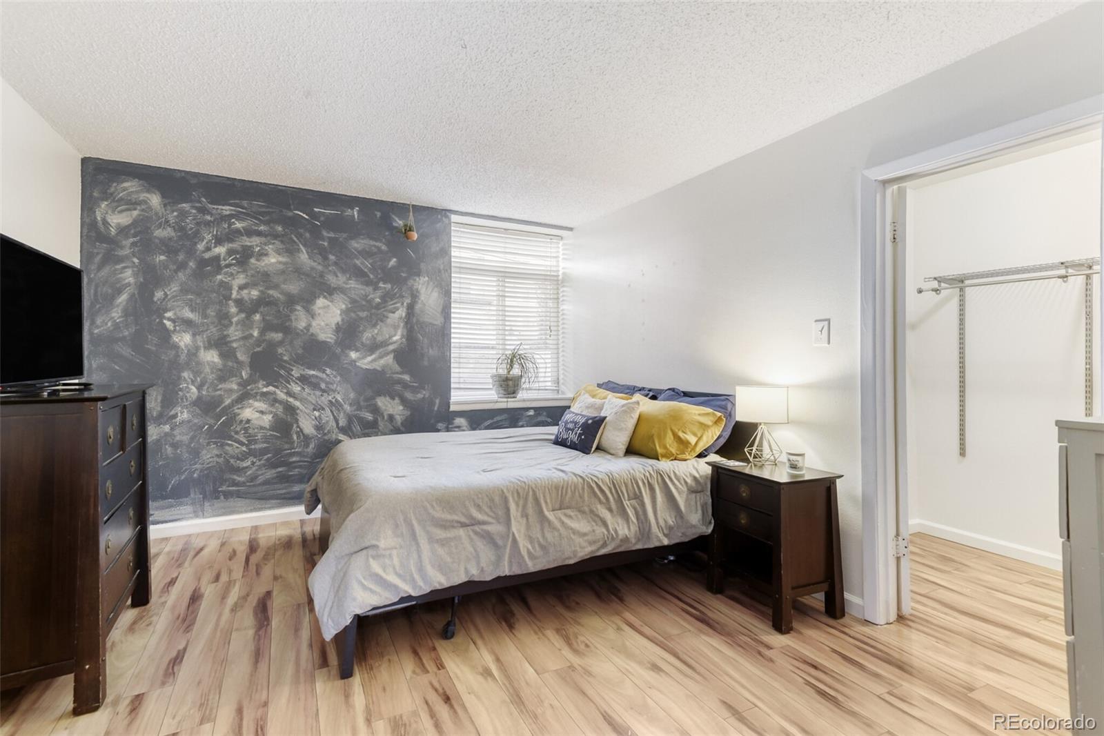 3428 South Locust Street, Unit B Denver, CO 80222 - Photo 7 of 9 a bedroom with a bed and a flat screen tv