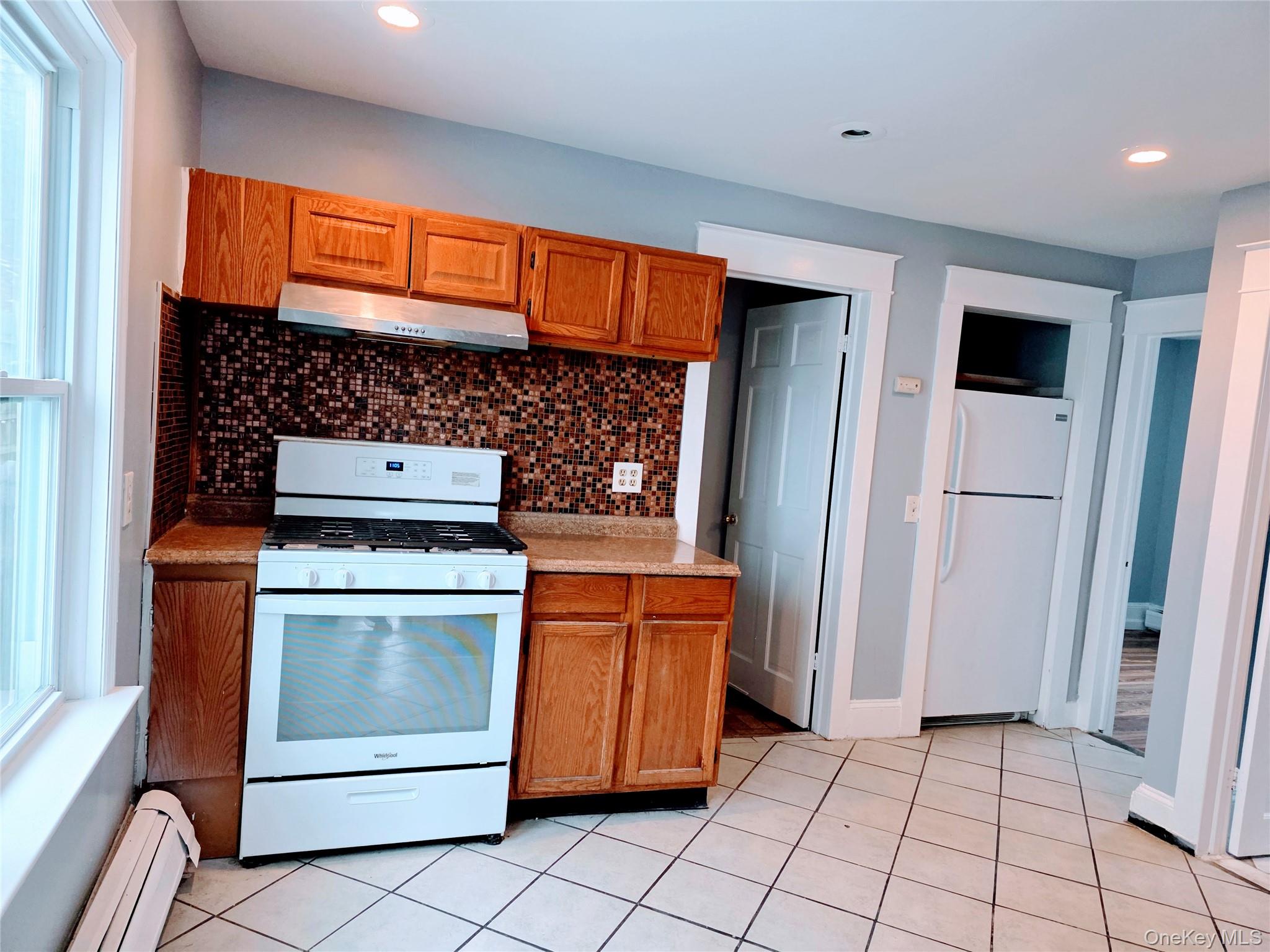 210 Smith Street Poughkeepsie, NY 12601 - Photo 14 of 44 a kitchen with white cabinets and white appliances