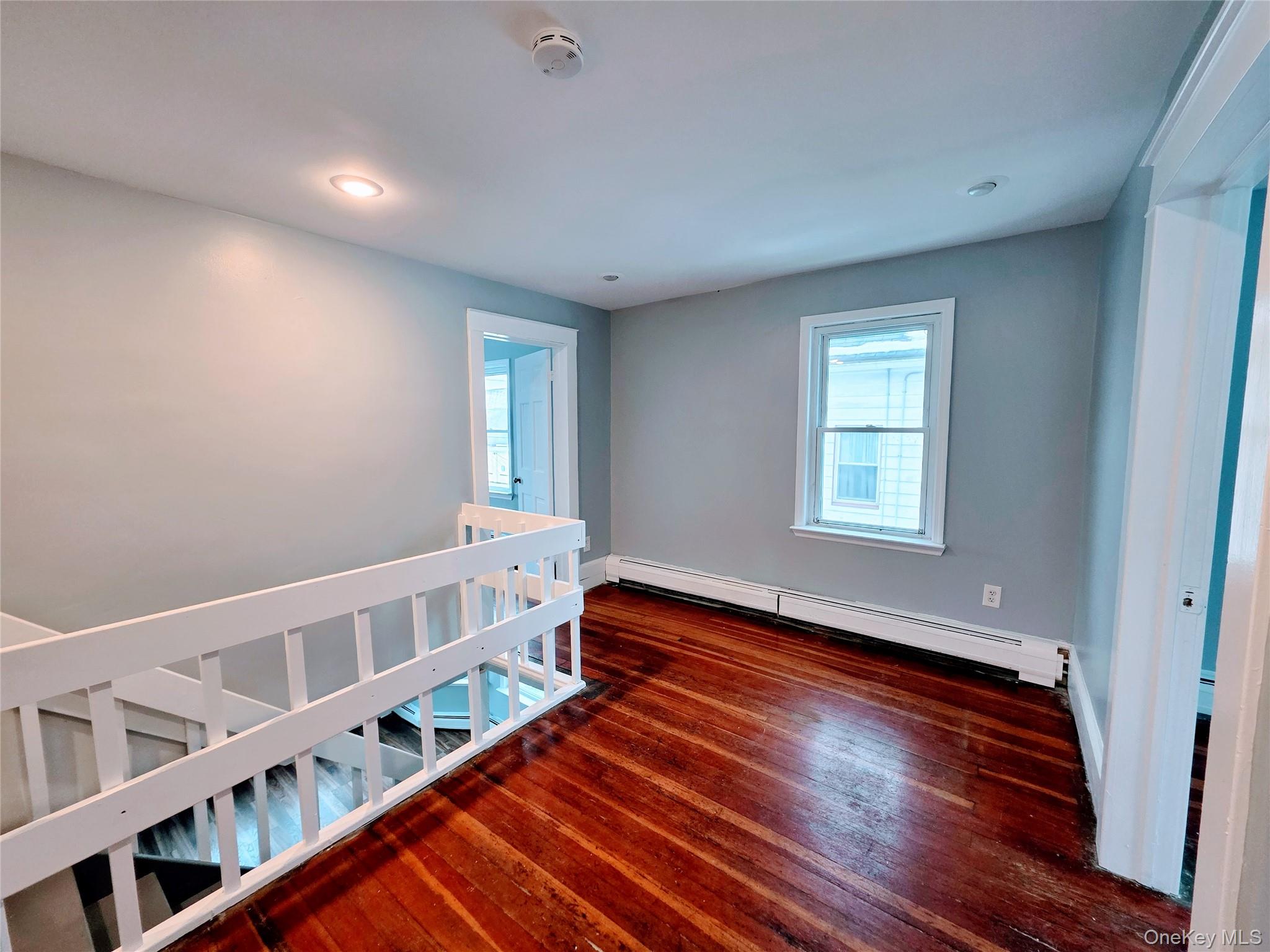 210 Smith Street Poughkeepsie, NY 12601 - Photo 22 of 44 a view of an empty room with wooden floor and a window