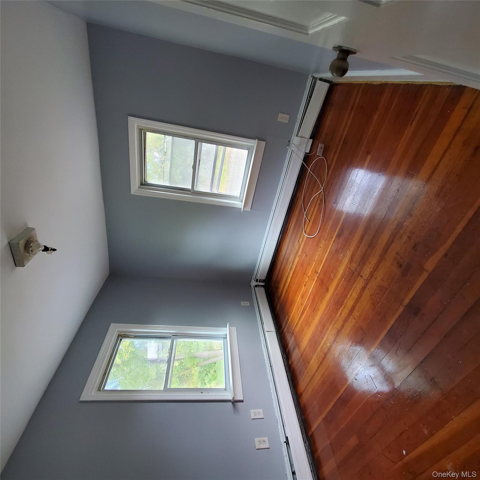 210 Smith Street Poughkeepsie, NY 12601 - Photo 27 of 44 an empty room with wooden floor and windows
