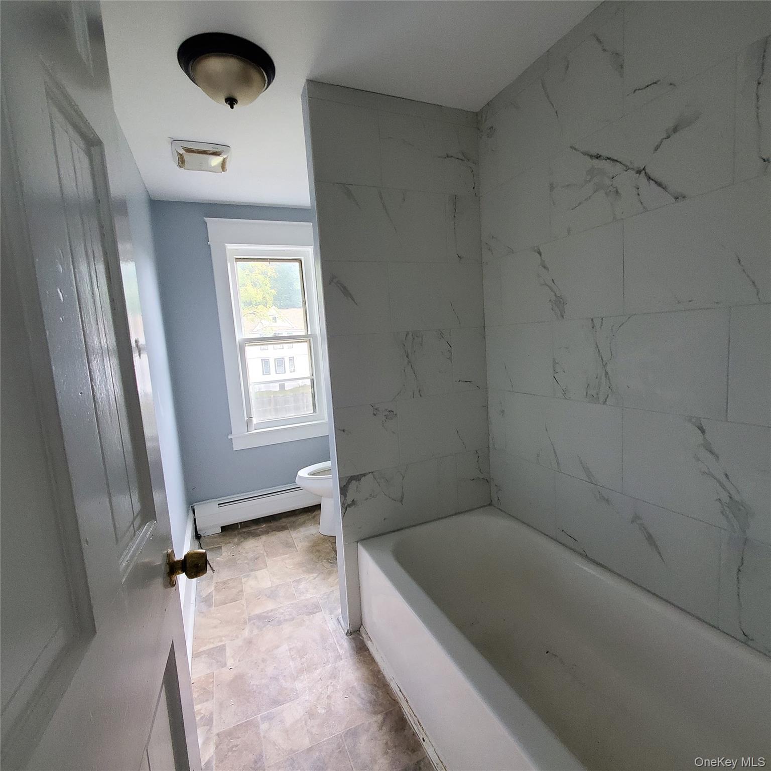 210 Smith Street Poughkeepsie, NY 12601 - Photo 30 of 44 a bathroom with a tub and a window