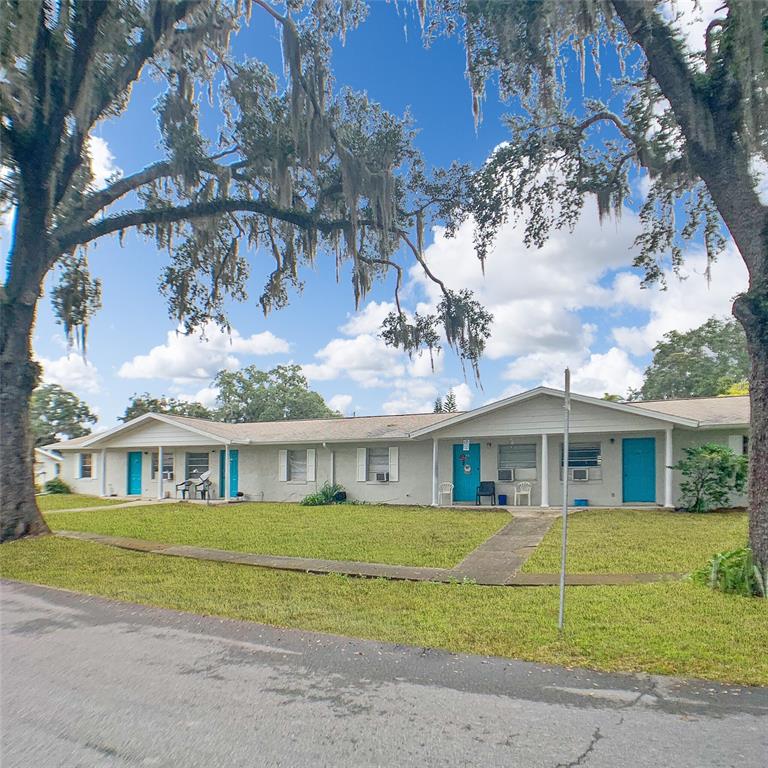 200 Church Street, Unit C4 Leesburg, FL 34748 - Photo 1 of 1 a view of a white house with a large windows and a yard with plants and large trees