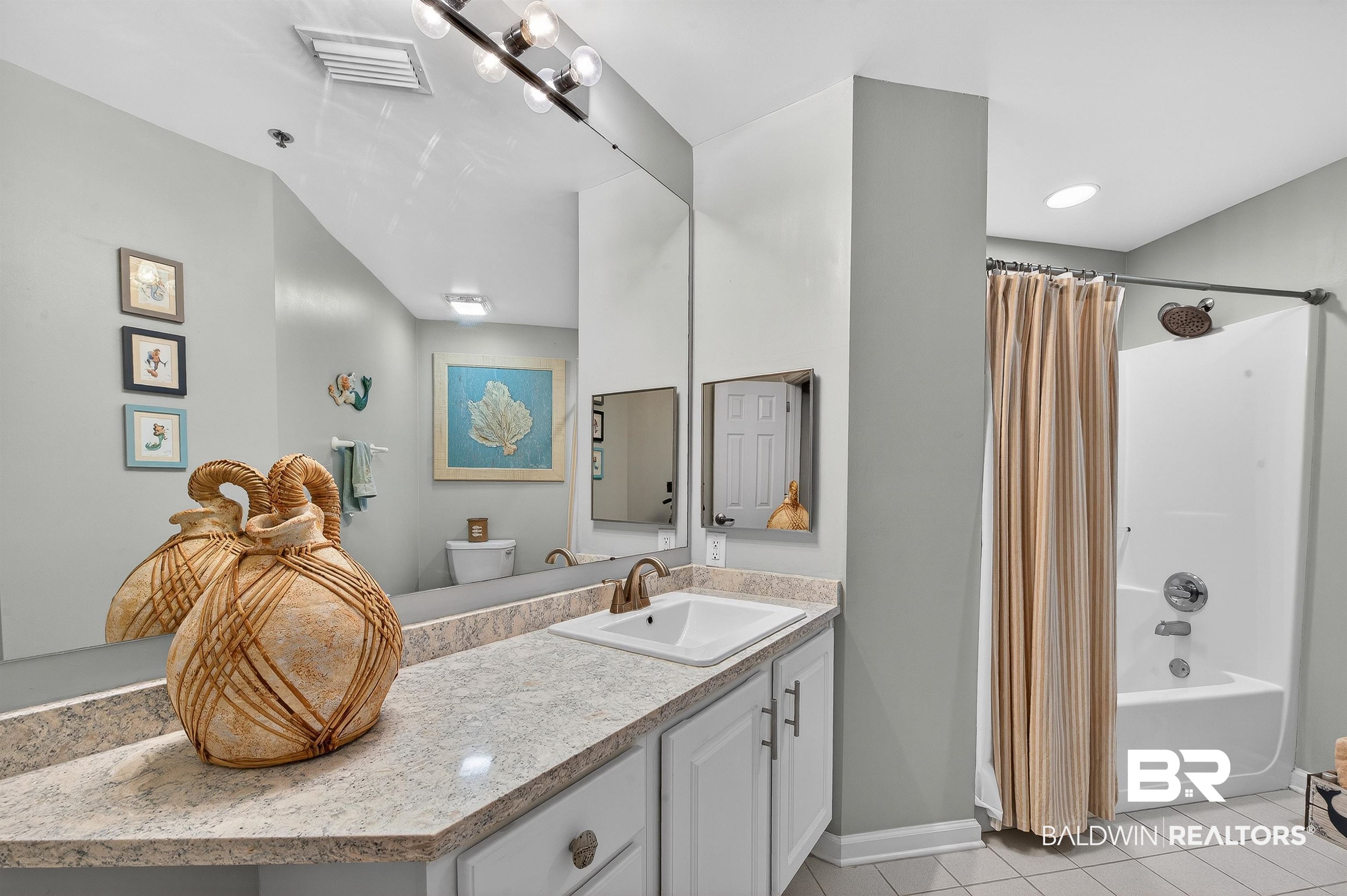 27282 Canal Road, Unit 408 Orange Beach, AL 36561 - Photo 16 of 37 Bathroom featuring shower / bathtub combination with curtain, vanity, and light tile patterned floors