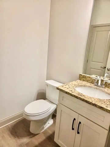 a bathroom with a granite countertop toilet and a sink