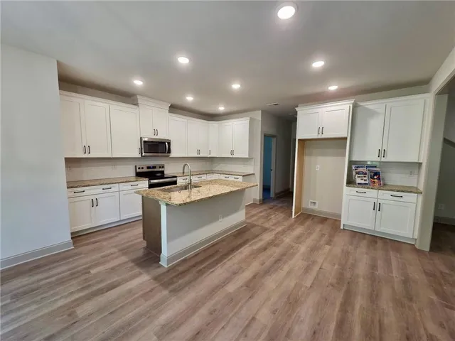 a kitchen with white cabinets and stainless steel appliances