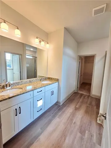 a spacious bathroom with a granite countertop sink toilet and mirror